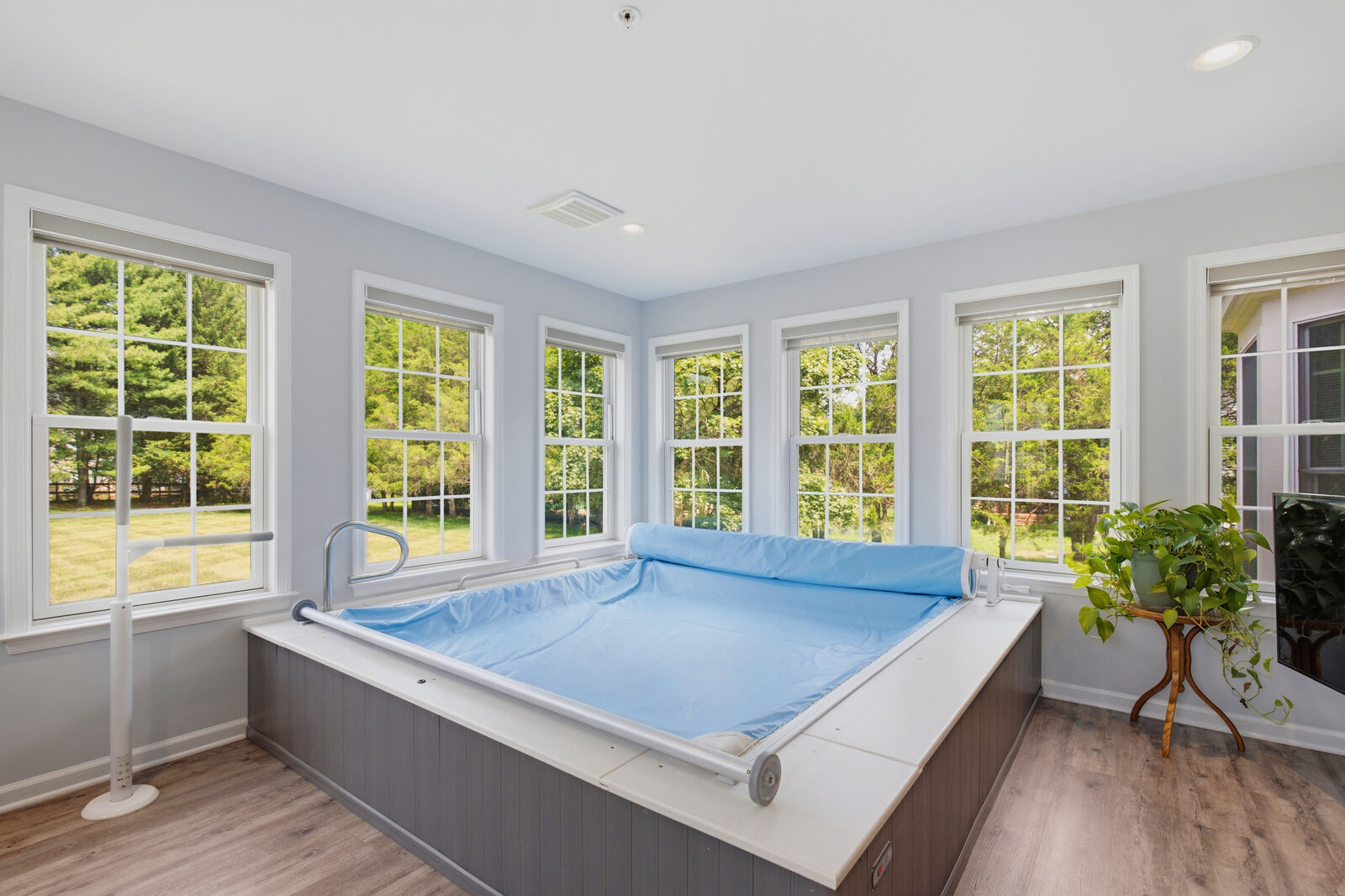 Sun-filled indoor pool room with windows on three sides
