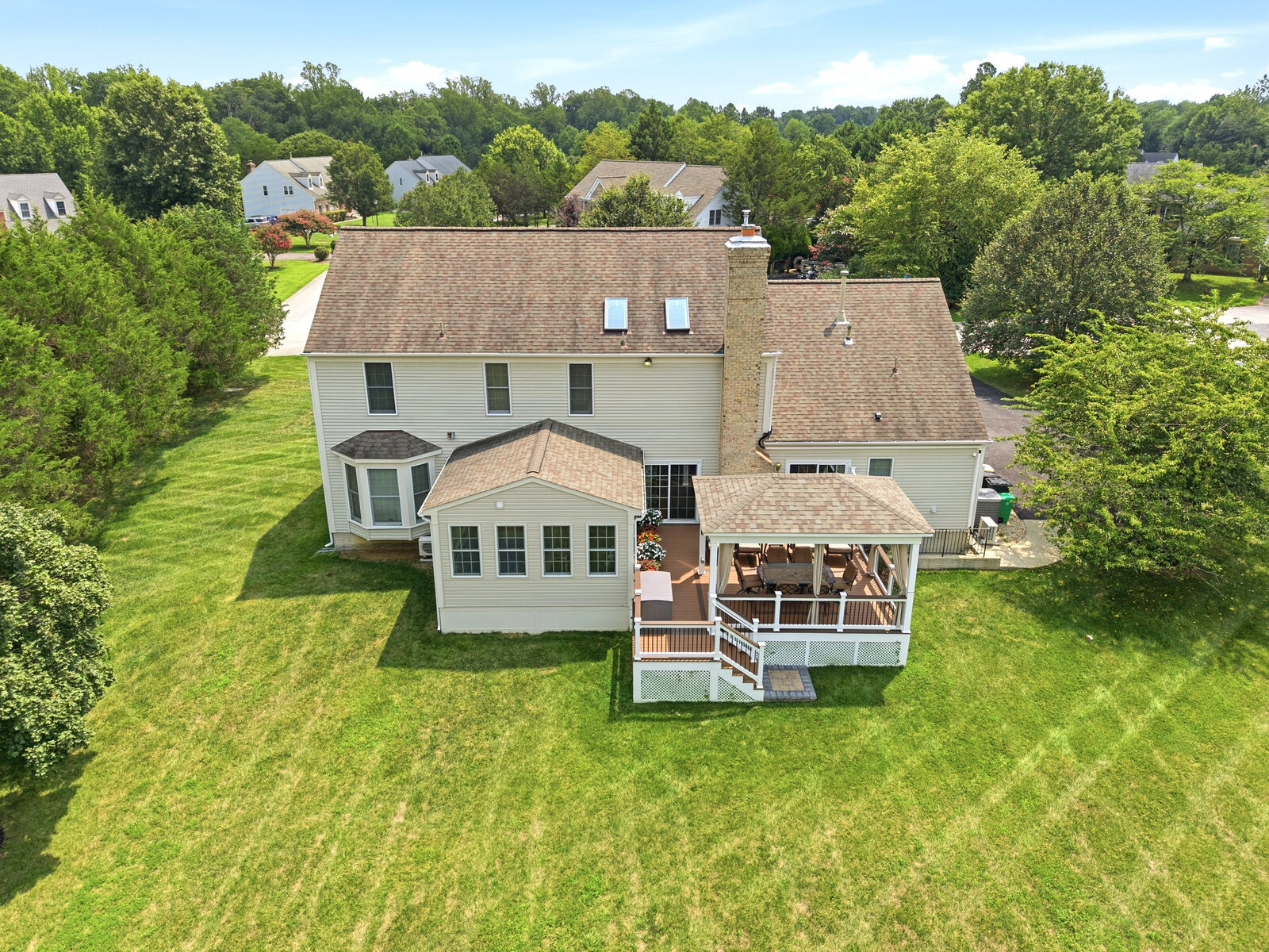 Aerial view of the rear of the home, deck and level yard